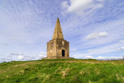 Ashurst beacon on hill against cloudy sky