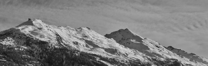 Low angle view of snowcapped mountains against sky