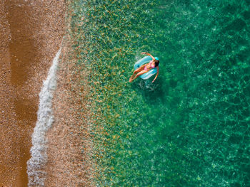 High angle view of woman swimming in sea