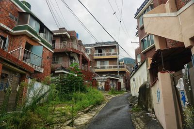 Narrow street amidst buildings in city against sky