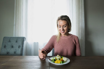 Portrait of a smiling young woman sitting at home