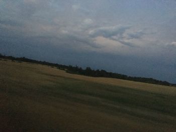 Scenic view of field against sky at dusk