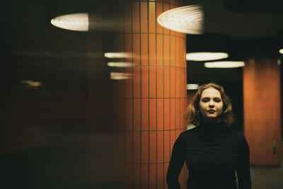 Portrait of woman standing in illuminated garage