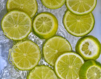 Limes close-up in liquid with bubbles. slices of green ripe limes in water. close-up fresh slices.