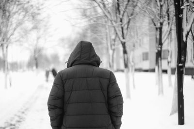 Rear view of woman on snow covered trees during winter