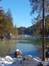 Scenic view of lake against clear blue sky during winter