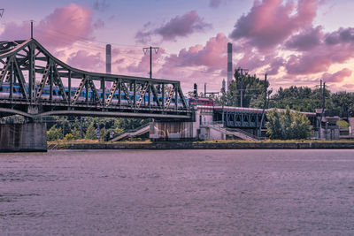 Bridge over river against sky during sunset