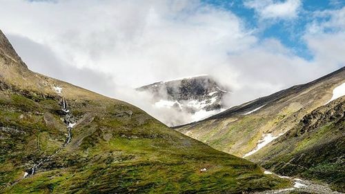 Scenic view of mountains against cloudy sky