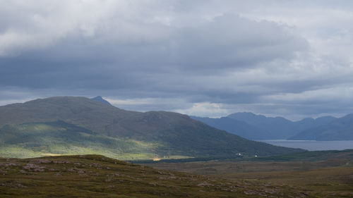 Scenic view of mountains against cloudy sky