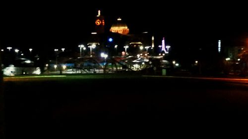 Illuminated cityscape against sky at night