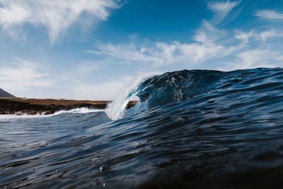Water splashing in sea against sky