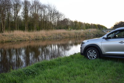 Reflection of car on grass against trees