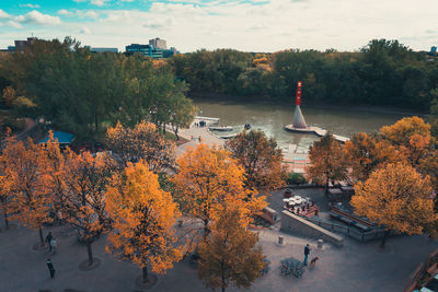 Trees in city against sky during autumn