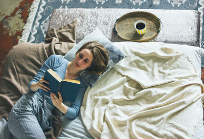 High angle view of man lying down on bed