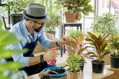 Man looking at potted plants on table