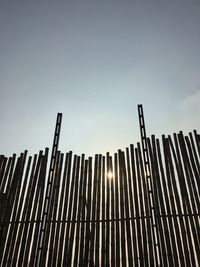 Low angle view of metal fence against sky