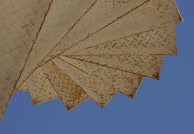 Low angle view of autumn leaf against clear blue sky