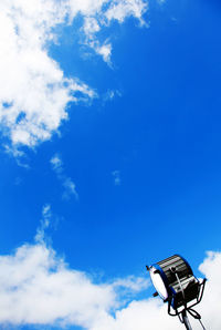 Low angle view of electric lamp against blue sky