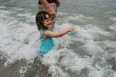 Full length of girl playing in sea