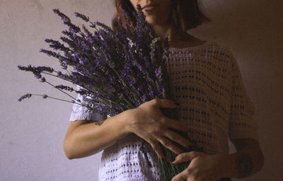 Midsection of woman holding lavender flower