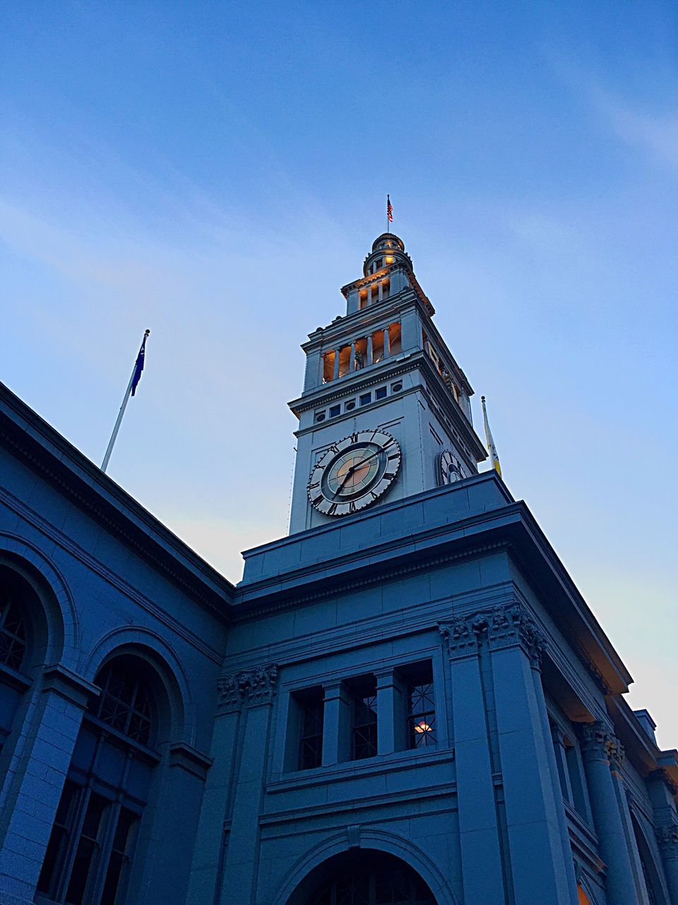 architecture, building exterior, low angle view, built structure, church, clock tower, religion, tower, sky, place of worship, blue, clock, window, clear sky, spirituality, city, high section, outdoors