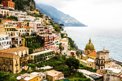 High angle view of townscape by sea against sky