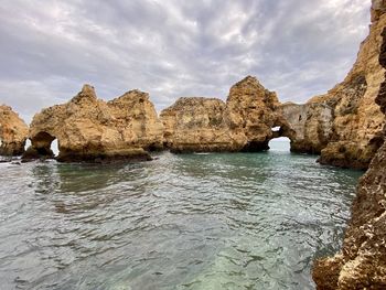 Scenic view of rocks in sea against sky