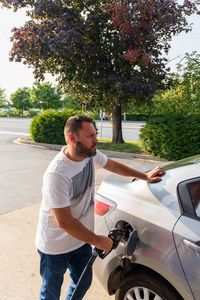 Side view of man riding push scooter on road