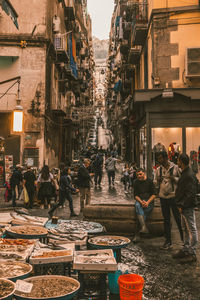 People on street amidst buildings in city