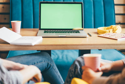 Midsection of woman using laptop on table