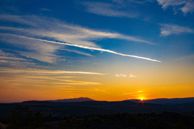 Scenic view of silhouette mountains against sky during sunset