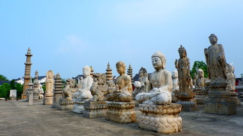 Statues at temple against sky