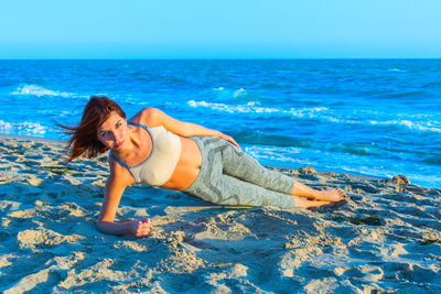 Full length of woman on beach against blue sky