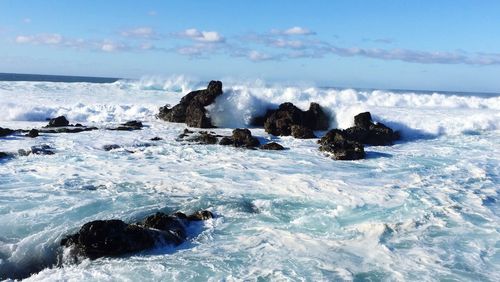 Scenic view of rocks in sea against sky