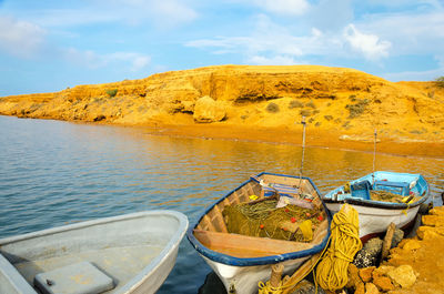 Boats moored at lake against sky