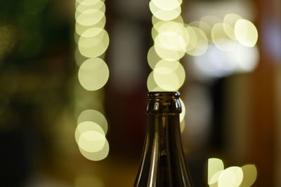 Close-up of wine bottle against lens flare