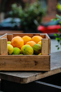 Close-up of oranges in container on table