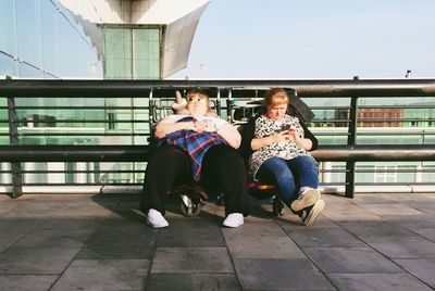 Rear view of woman sitting on bench