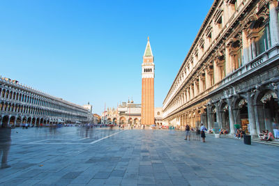 People in town square against clear blue sky