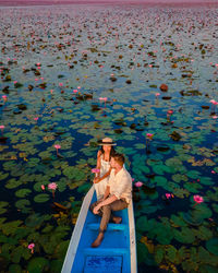 Side view of woman sitting by lake