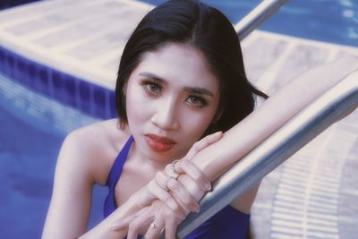 Portrait of young woman sitting in swimming pool