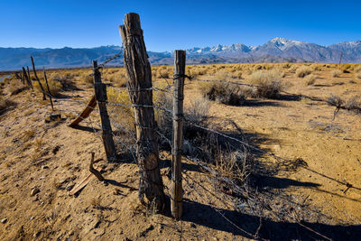 Rustic handmade fence in valley desert and distant snowy sierra nevada mountains