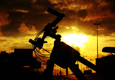 Silhouette sculpture against dramatic sky during sunset