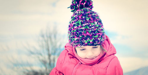 Close-up portrait of young woman standing against sky