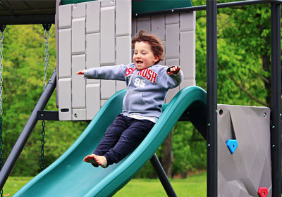 Happy boy in playground on slide