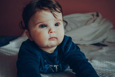 Cute baby girl on bed at home