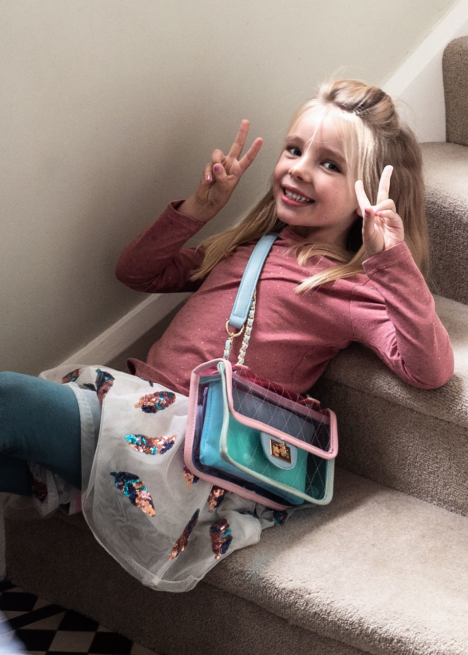 PORTRAIT OF A SMILING GIRL WEARING MASK AT HOME