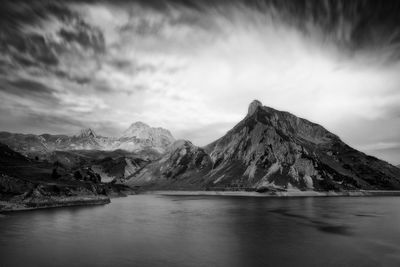 Scenic view of lake by mountains against sky