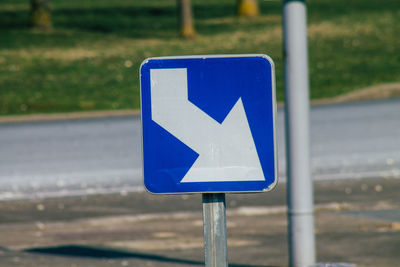 Close-up of arrow sign on road