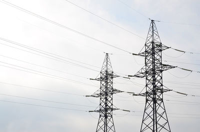 Low angle view of electricity pylon against sky